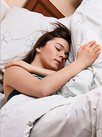 Beautiful Lily C is lying on the bed and pulling her slender lon