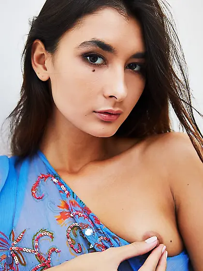 Smoldering Russian brunette plays with her nipples while posing