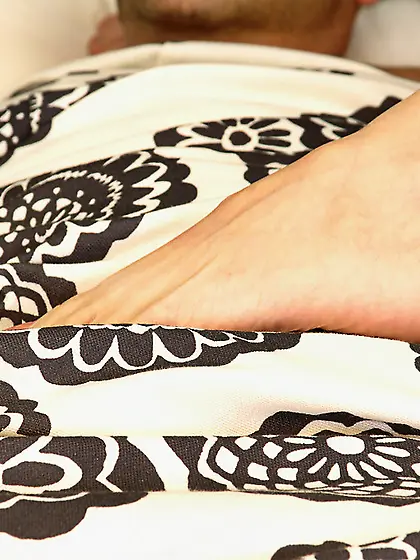 Girl puts her foot on sleeping man waking him up for a morning f
