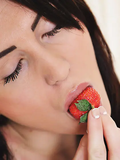 Brunette eats her strawberry in a suggestive way, strips naked V