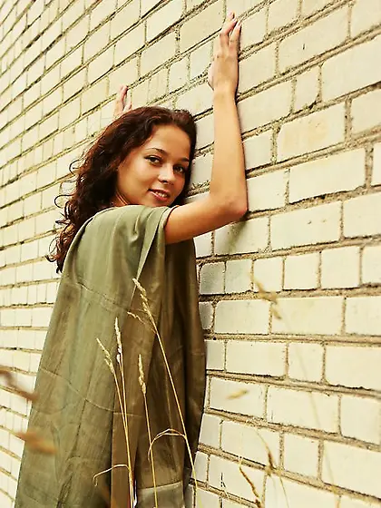 Joyful brunette with wavy hair gladly demonstrates her big tits