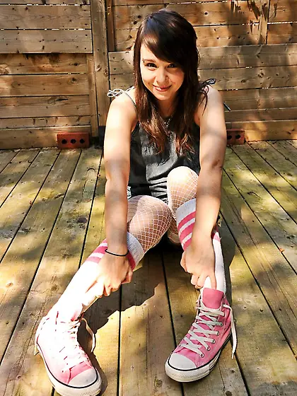 Ariel Rebel sits down on the wooden porch,  shows her boobs and s