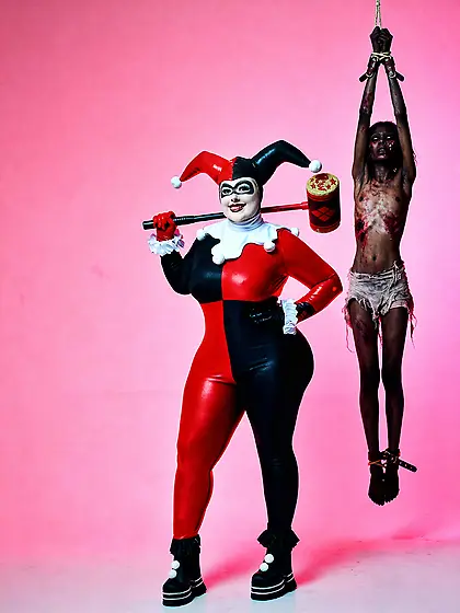 A nigger hangs behind Harley Quinn
