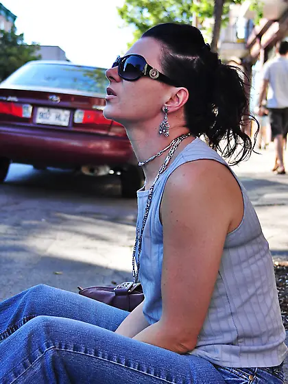 Brunette babe smoking while loitering on the street